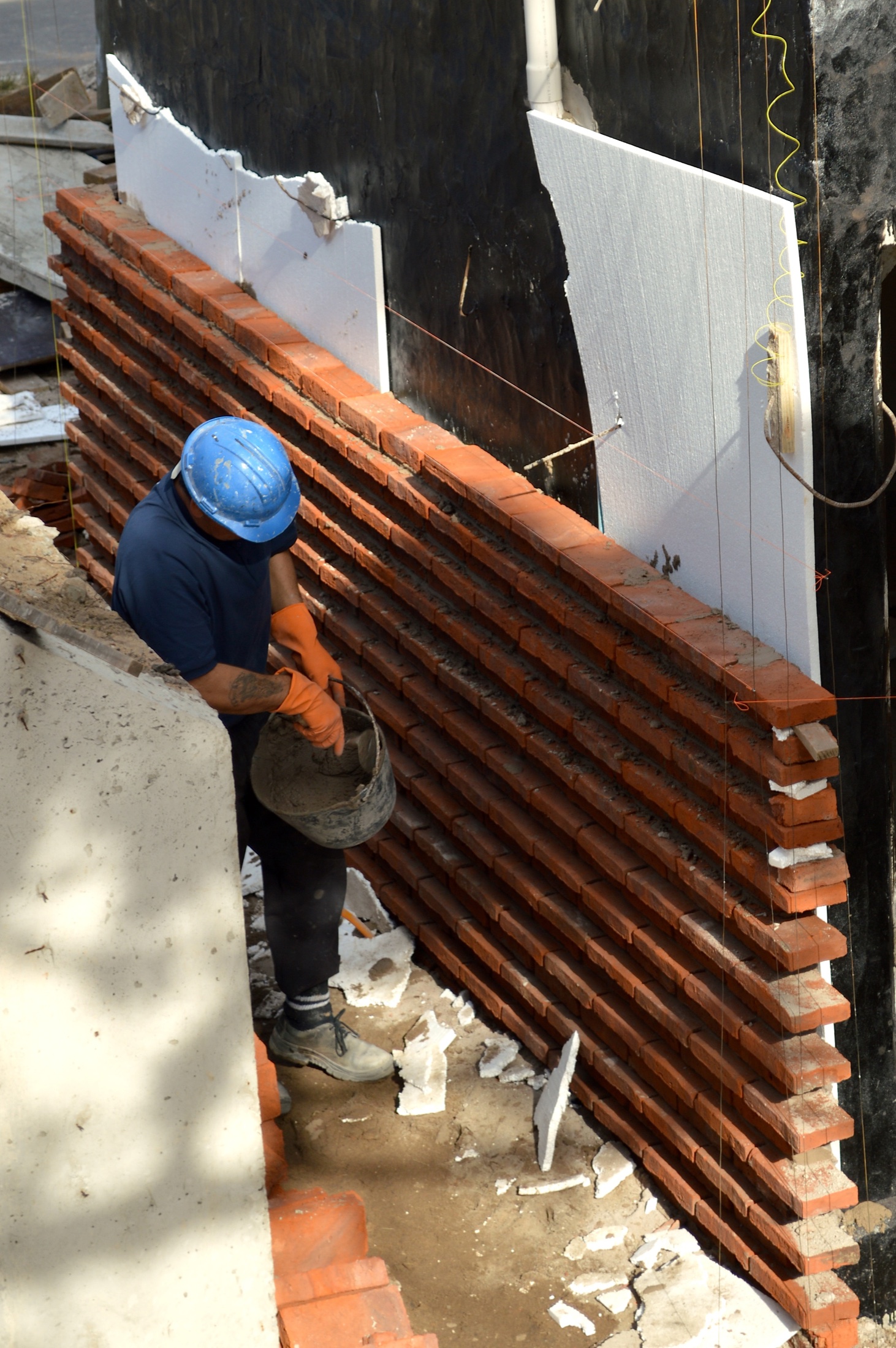 Albañil construyendo una fachada de ladrillo
