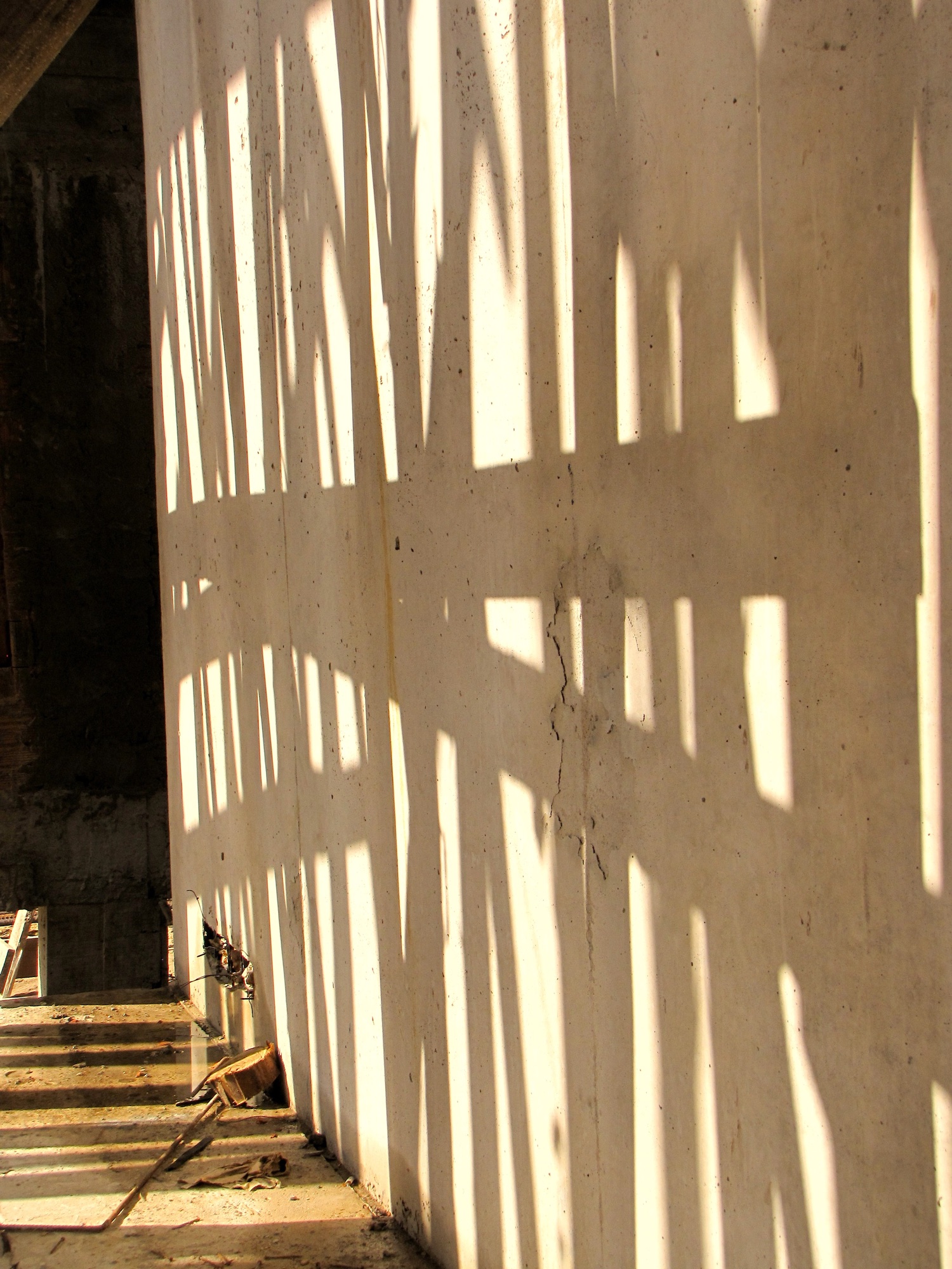 Sombras de puntales sobre un muro en obra