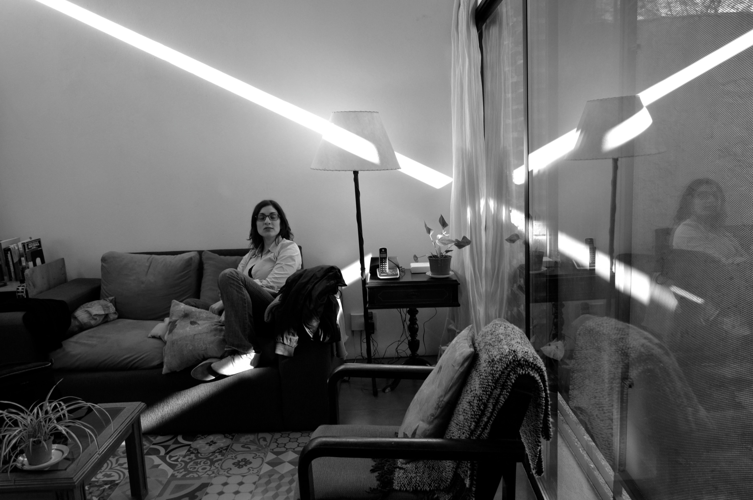 Interior de Casa Malvi atravesado por una línea de luz y reflejos