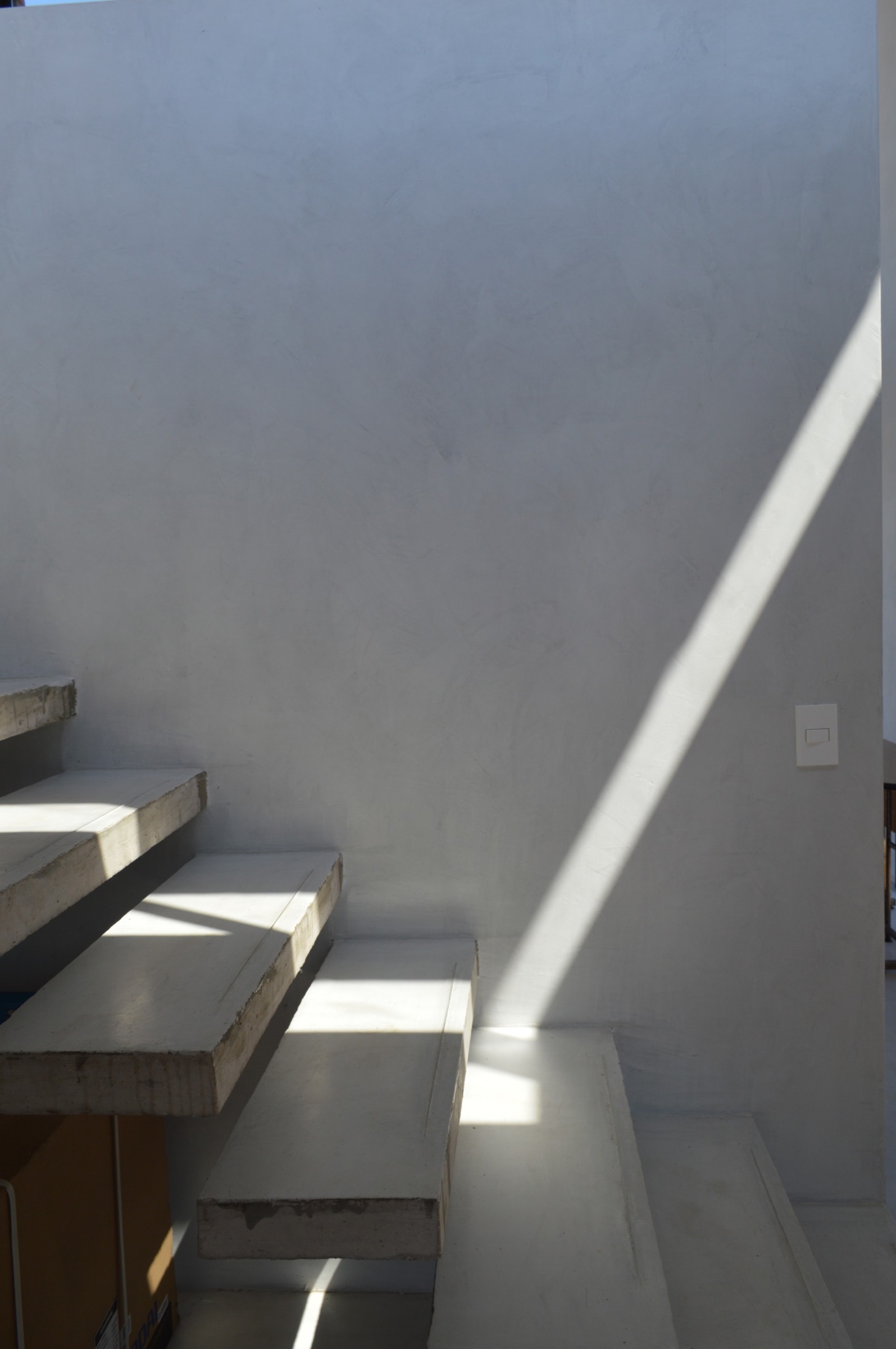 Haz de luz diagonal sobre la escalera de Casa I